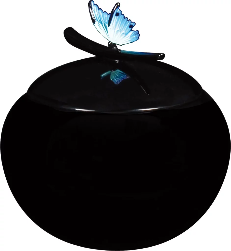 Urne cinéraire ronde noire ornée d'un papillon bleu sur le couvercle.