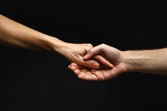 Deux mains qui se tiennent fermement en signe de soutien et de confort.